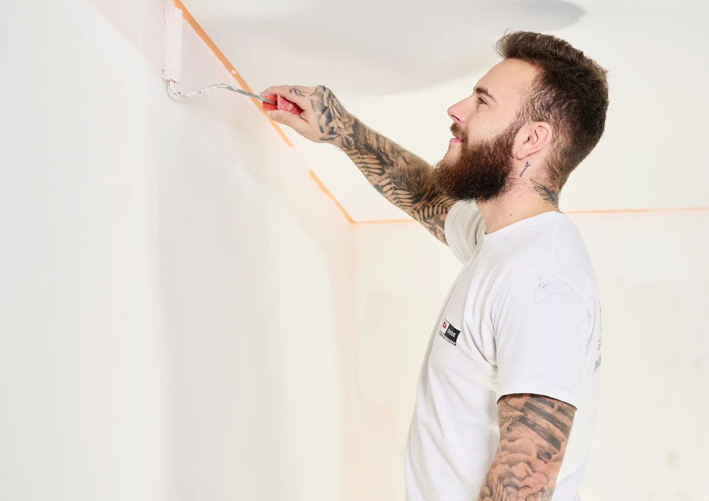 Maler beim Streichen einer Wand mit der Rolle
